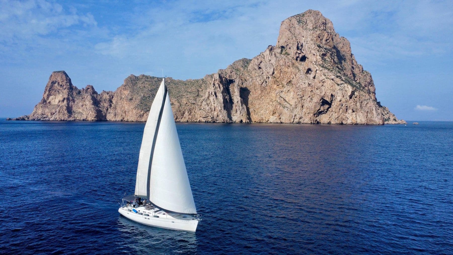 Velero navegando frente al islote de Es Vedrà